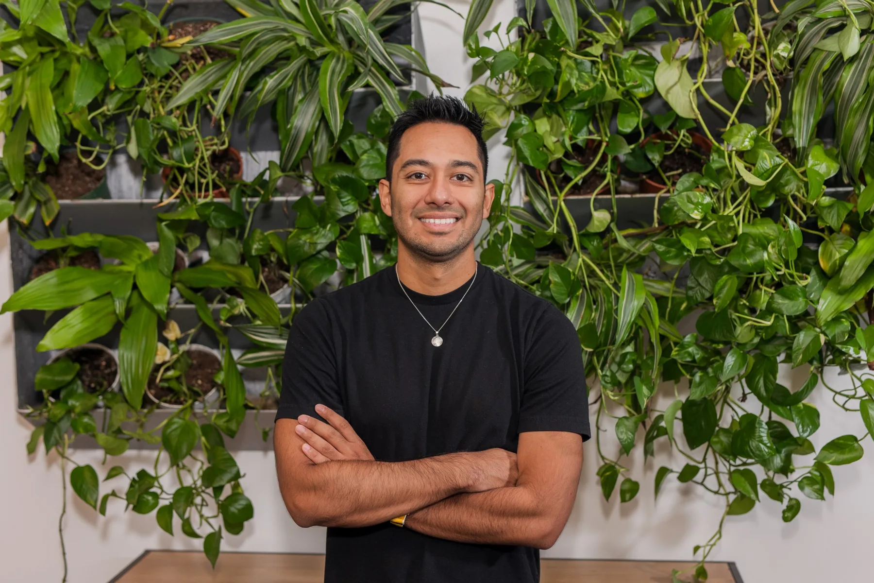 Jose Paez standing in front of a living plant wall